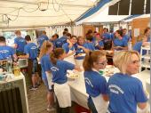 Viele blaue T-Shirts wuseln durch die K&uuml;che. Jede/r hat seine Aufgaben und wei&szlig;, was zu tun ist. Anders w&uuml;rden wir die Aufgaben nicht bew&auml;ltigen k&ouml;nnen. Sch&ouml;n, dass Gitte und Elfriede da noch Zeit zum Scherzen haben. 